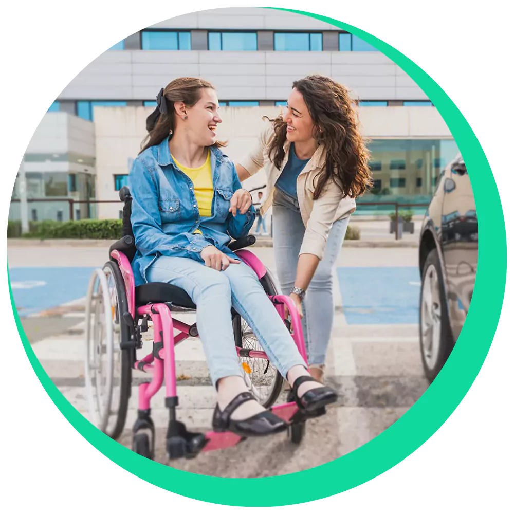 Disabled woman in wheelchair smiling with support worker